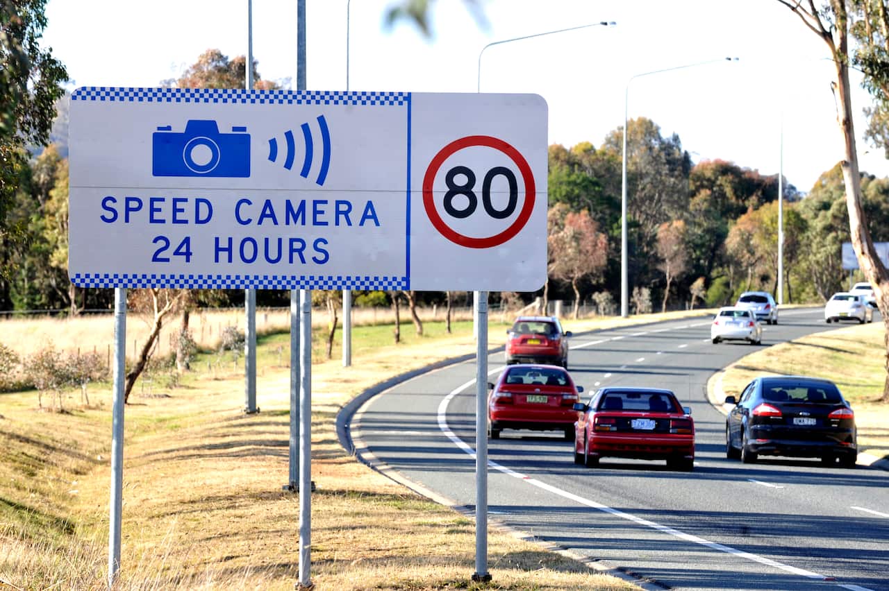 A speed camera warning sign.