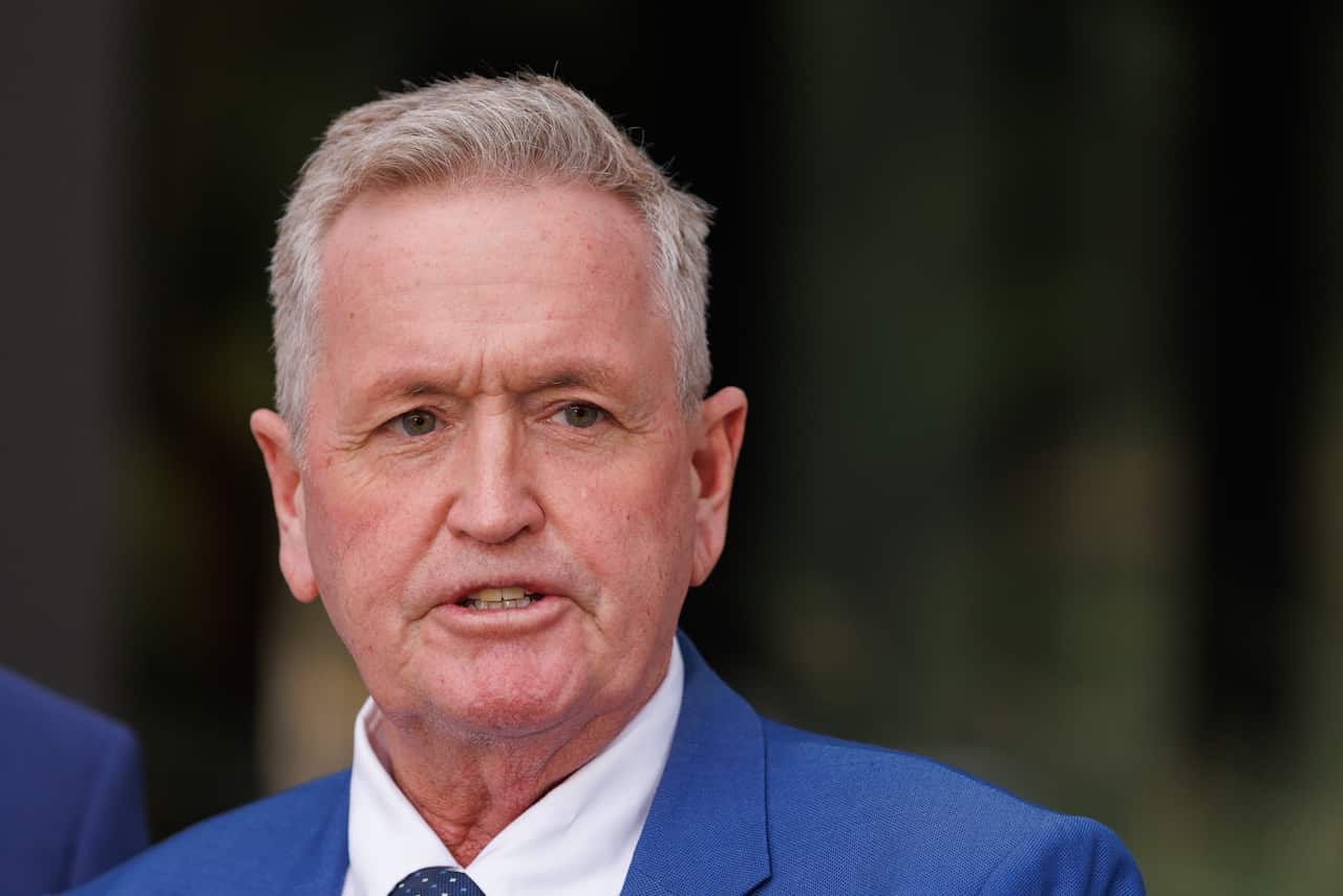 A man in a blue suit speaks.