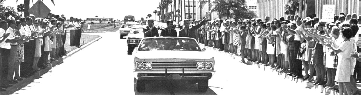 Apollo 10 astronauts Thomas P. Stafford, left, John W. Young, and Eugene A. Cernan wave to employees as they ride in a convertible through NASA’s Kennedy Space Center in Florida