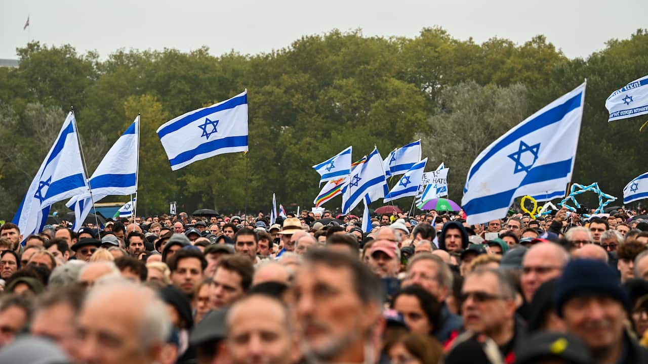People holding Israeli flags at a memorial event.