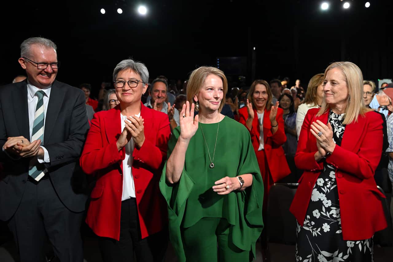 Home Affairs Minister Tony Burke, Foreign Affairs Minister Penny Wong, former Prime Minister Julia Gillard, and Finance Minister Katy Gallagher clap while at the Labor party's election campaign launch.