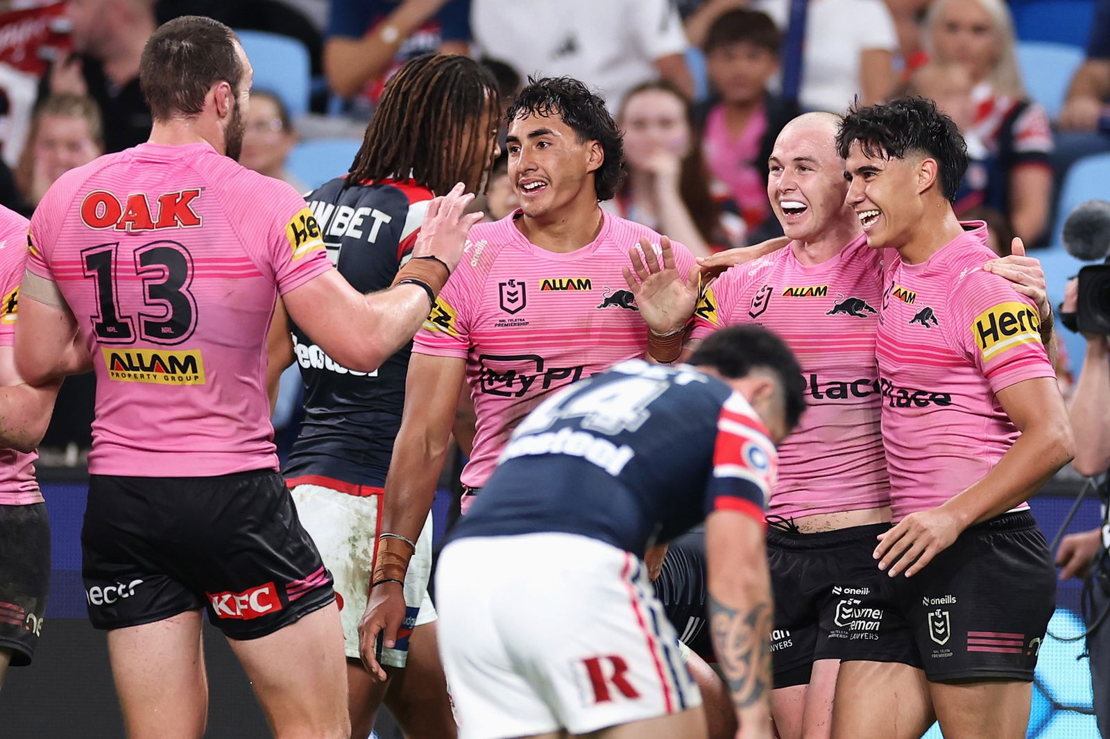 Panthers players celebrate after a try against the Roosters.