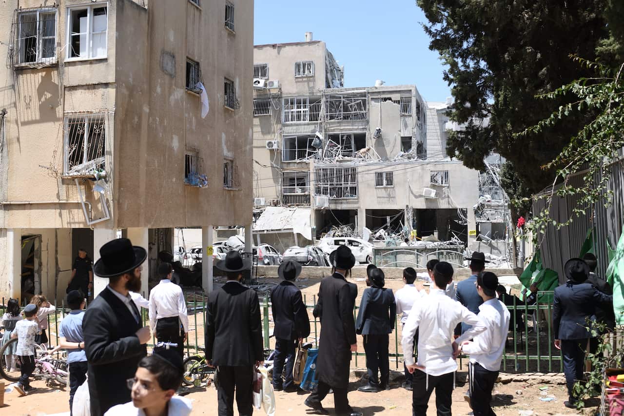 People looking at a building that has been destroyed.