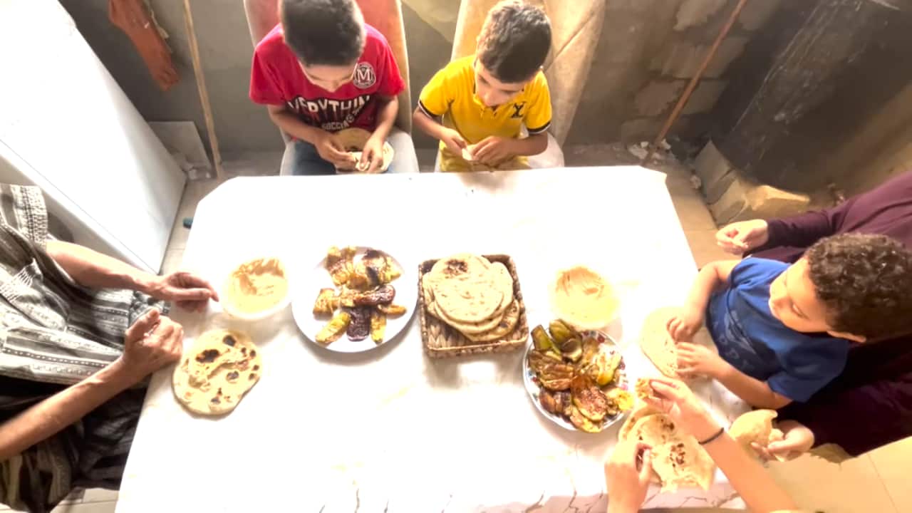 A family around a table with food.