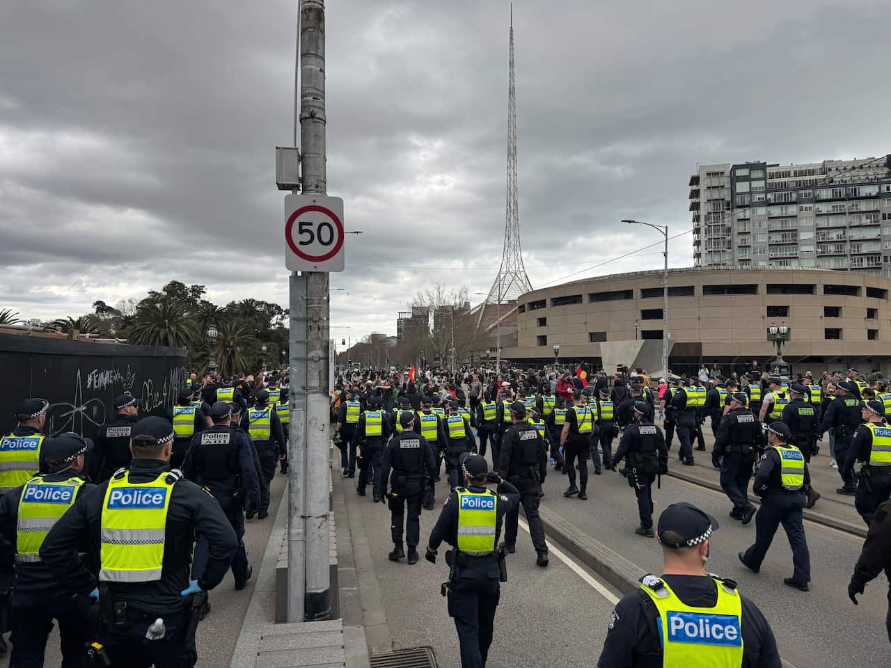 A group of police walking on a road.
