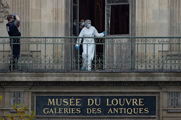 A French Forensics Officer examines the cut window and balcony of a gallery at the Louvre Museum which was the scene of a robbery at the world-famous museum earlier in the day.