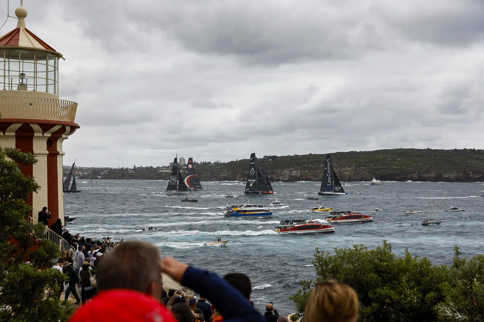 Spectators at South Head look on as Law Connect leads the fleet during the start of the 2025 Sydney to Hobart on Sydney Harbour on December 26, 2025 in Sydney, Australia.