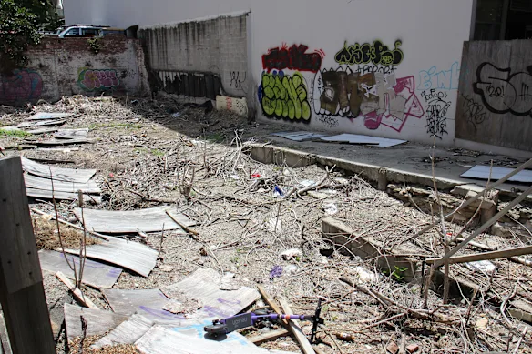 The site at 440 Upper Edward Street in Spring Hill on Thursday afternoon, with a dumped Neuron e-scooter in the foreground. 