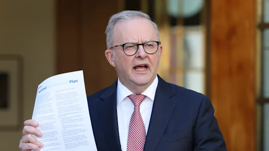 Prime Minister Anthony Albanese holds up a copy of the national fuel plan at Monday’s press conference.