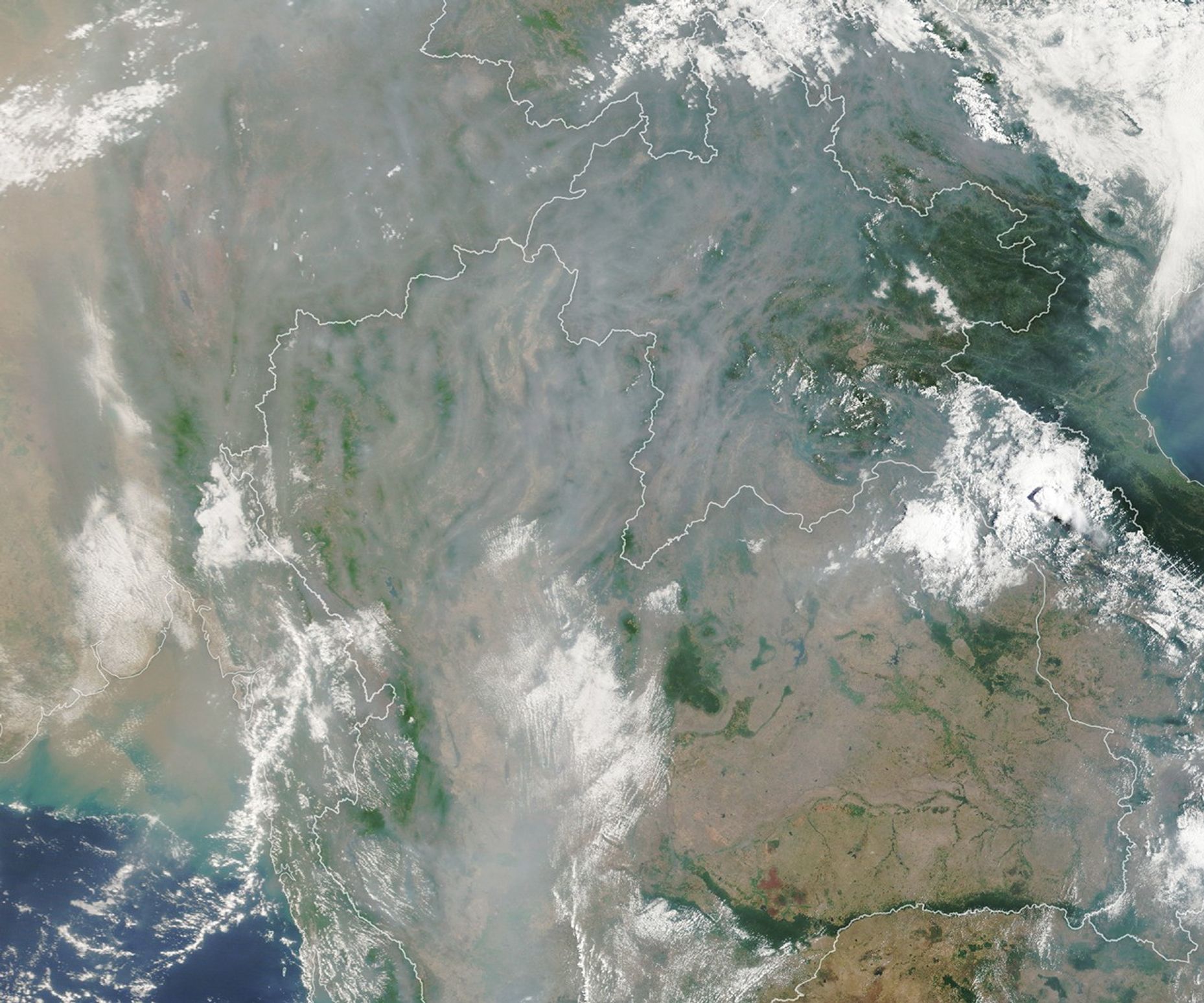 A satellite image shows gray smoke obscuring most of the landscape around Chiang Mai except for small areas where mountain ridges are visible.