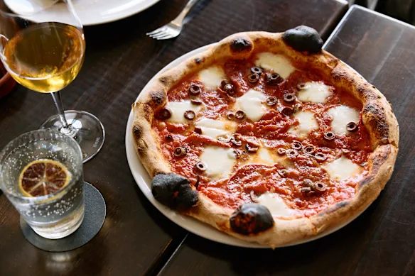 Salmino piccante pizza with with tomato sugo, mozzarella, spicy salami and kalamata olives.