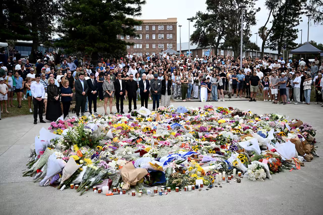 Mourners place flowers at a memorial at Bondi Beach.