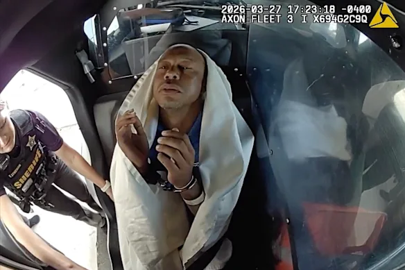 Tiger Woods strapped into a patrol car after his arrest.